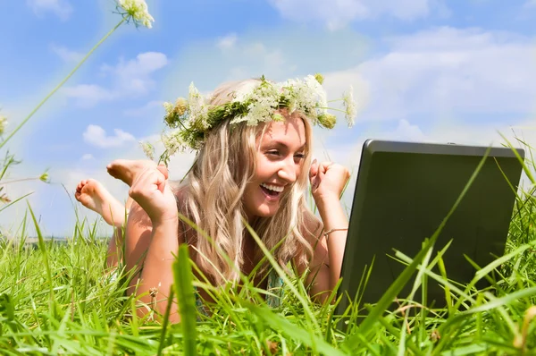 Mooi meisje op de weide met laptop — Stockfoto