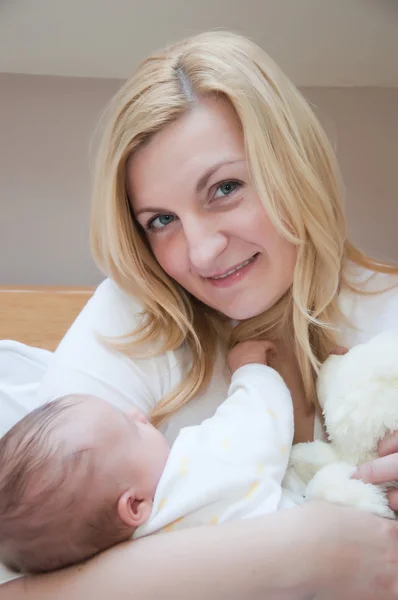Retrato de jovem mãe feliz com bebê recém-nascido em casa — Fotografia de Stock