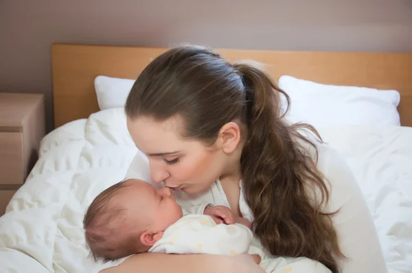 Portrait of young happy mother with newborn baby at home — Stock Photo, Image