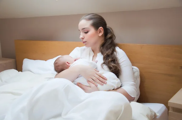 Porträt einer jungen glücklichen Mutter mit Neugeborenem zu Hause — Stockfoto