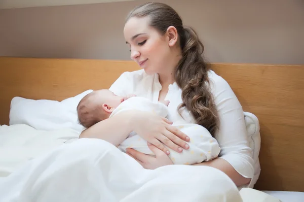Retrato de jovem mãe feliz com bebê recém-nascido em casa — Fotografia de Stock