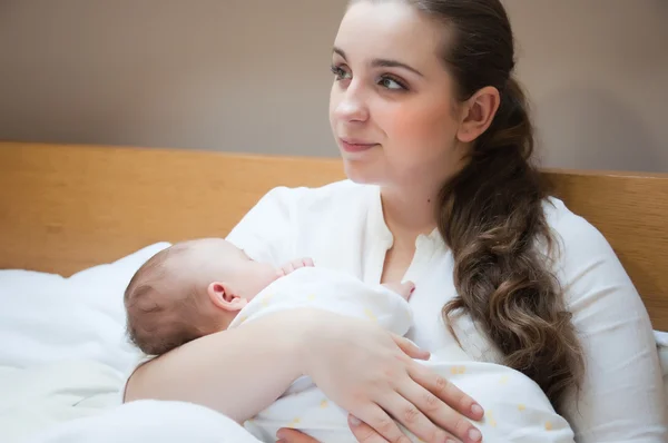 Portrait of young happy mother with newborn baby at home — Stock Photo, Image