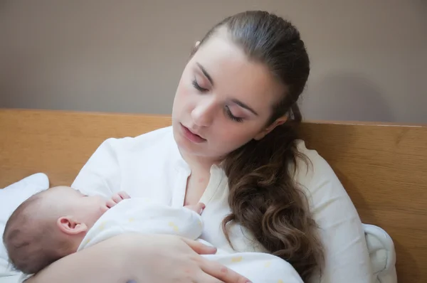 Портрет молодої щасливої матері з новонародженою дитиною вдома — стокове фото