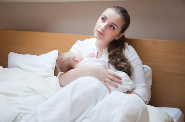 Porträt einer jungen glücklichen Mutter mit Neugeborenem zu Hause — Stockfoto