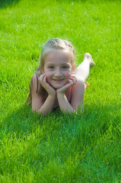 Szczęśliwa dziewczynka leżący w parku — Zdjęcie stockowe