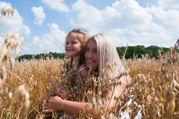 Mother and daughter playing at corn — Stock Photo, Image
