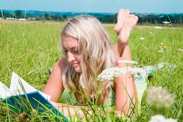 美しい少女の牧草地の本で — ストック写真