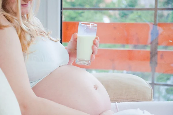 Беременная женщина со стаканом молока — стоковое фото