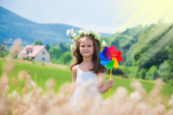 Girl playing with windmill — Stock Photo, Image
