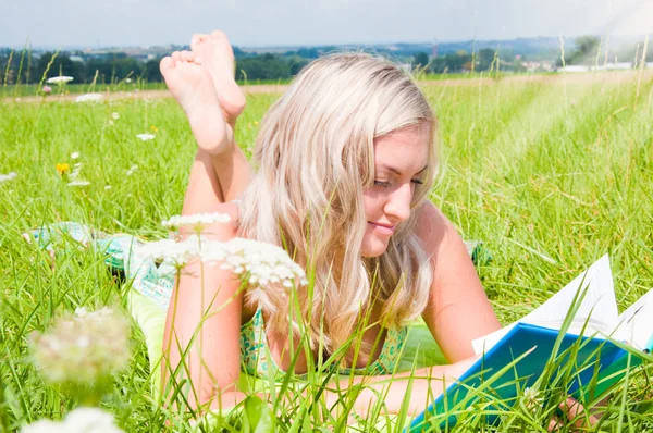 Krásná mladá dívka na louce s knihou — Stock fotografie