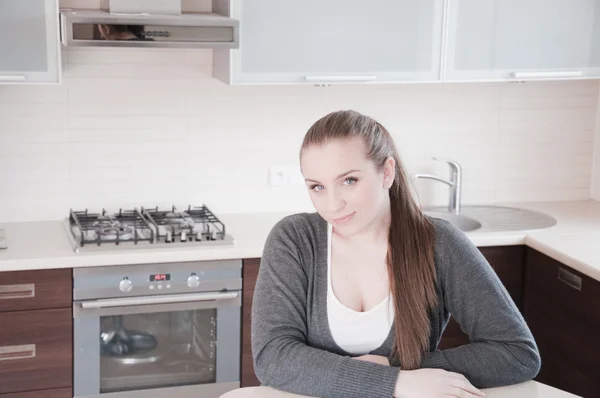 Portret van mooie ontspannen jonge vrouw aanbrengen op de keuken - binnen — Stockfoto