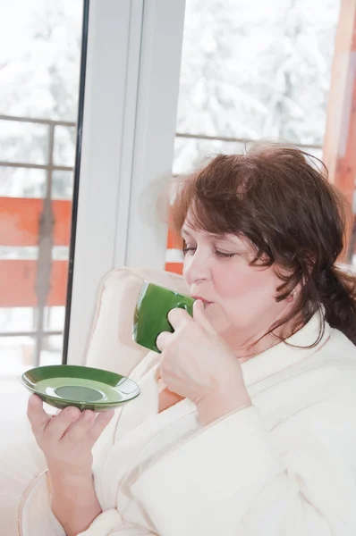 Äldre kvinna dricka kaffe hemma — Stockfoto