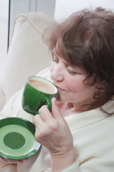 Oudere vrouw drinken koffie thuis — Stockfoto