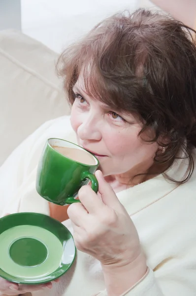 Starší žena pít káva doma — Stock fotografie