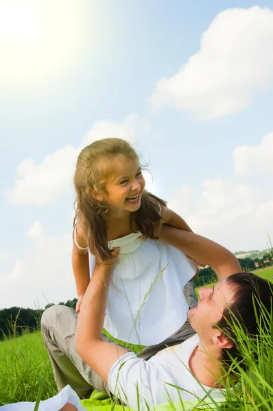 Vader en dochter spelen in de weide — Stockfoto