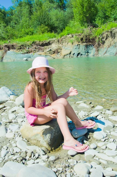 Милая маленькая девочка играет на реке — стоковое фото
