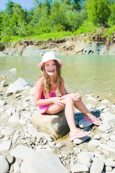 Милая маленькая девочка играет на реке — стоковое фото