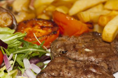 Grilled steak with chips and salad clipart