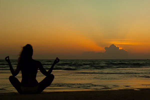 Silueta ženy meditovat u moře Royalty Free Stock Fotografie