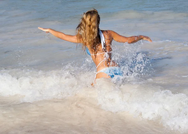 Mujer sexy corriendo en olas en la playa caribeña — Foto de Stock