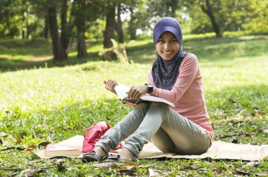 güzel genç Müslüman Bayan sit okurken mat