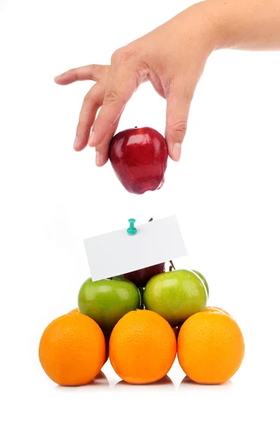 Πολύχρωμο πυραμίδα φρούτα με το ένα χέρι κρατήστε ένα μήλο απαλά — Φωτογραφία Αρχείου
