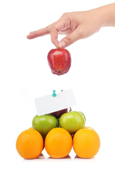 Pirâmide colorida de frutos com uma mão segura uma maçã — Fotografia de Stock