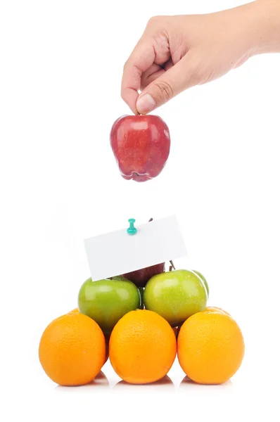 Pirámide colorida de frutas con una mano sostiene una manzana con el dedo —  Fotos de Stock