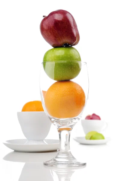 Mix of juicy fruits in glass and cup — Stock Photo, Image