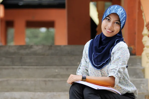 Beautiful young muslim lady smile while holding books at the par — Stock Photo, Image