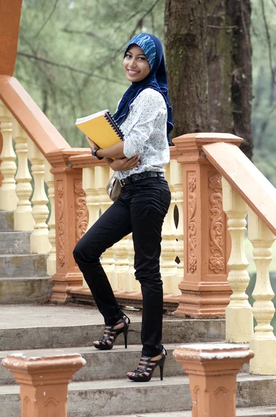 Mooie jonge moslim dame permanent en glimlach in het park — Stockfoto