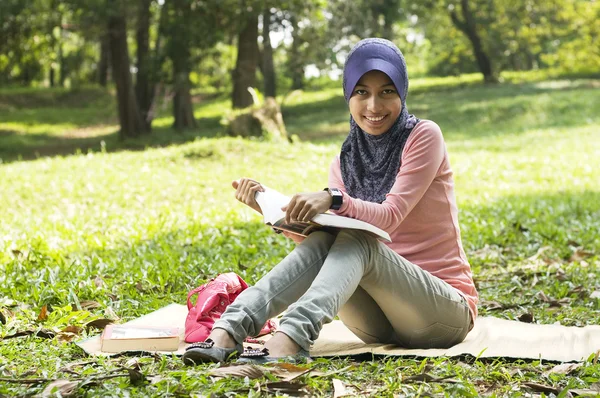 Bela jovem senhora muçulmana sentar-se no tapete de leitura — Fotografia de Stock