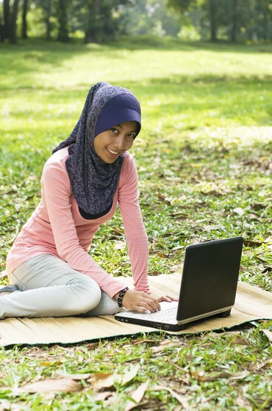 Bela jovem senhora muçulmana sentar-se no tapete com caderno — Fotografia de Stock