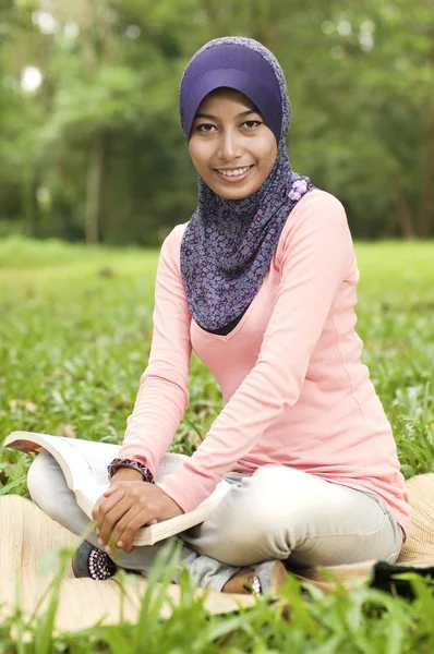 Beautiful young muslim lady smiling holding book — Stock Photo, Image