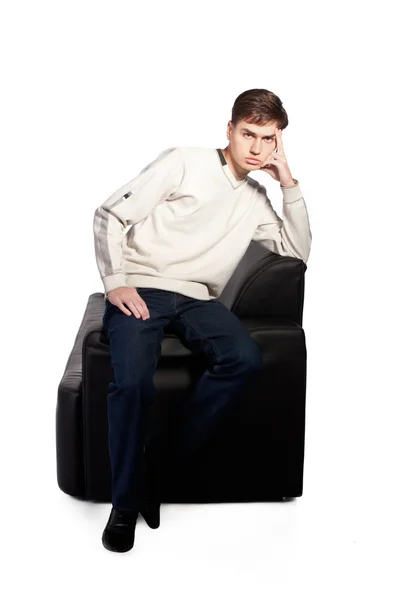 Zadumany młodzieniec na kanapie — Zdjęcie stockowe