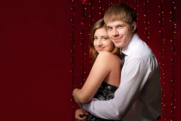 Couple embracing against the backdrop of lights — Stock Photo, Image