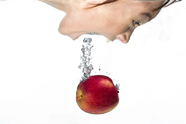 Chica se sumerge en la manzana . —  Fotos de Stock