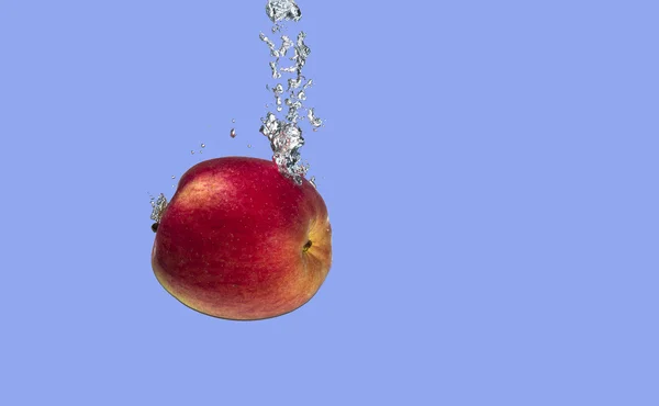 Una mela rossa in acqua . — Foto Stock