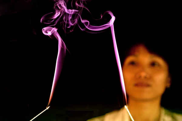 Mulher assiste incenso fumaça . — Fotografia de Stock