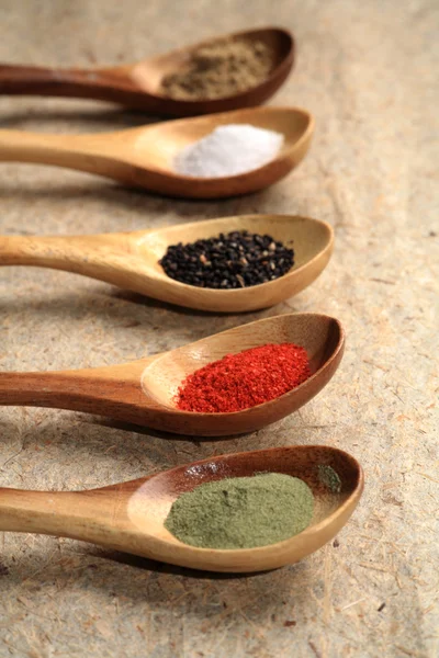 stock image Colored spices on wooden spoons.