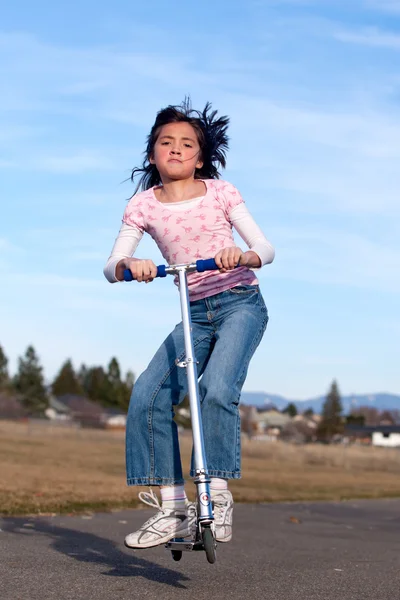 Girl jumps on a scooter. — Stock Photo, Image