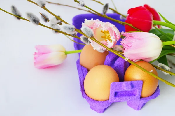 Uova con fiori di tulipano e rami di salice Immagini Stock Royalty Free