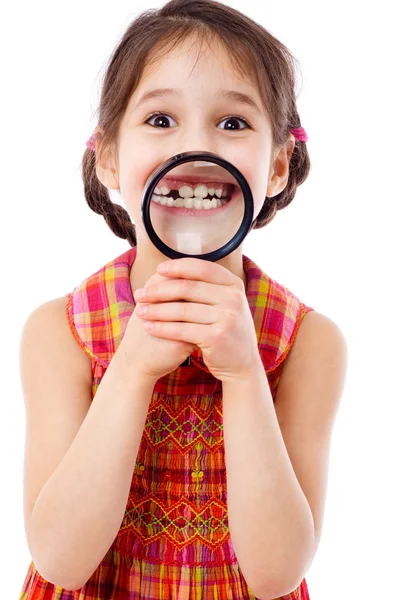 Девушка показывает зубы через лупу — стоковое фото