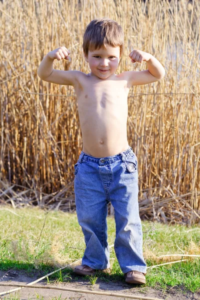 Criança forte mostrando os músculos — Fotografia de Stock