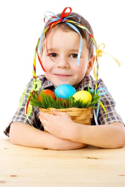 Smiling boy with easter eggs in basket — Stock Photo, Image