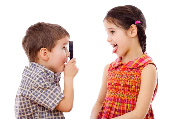 Chlapec se dívá na dívku s lupou — Stock fotografie