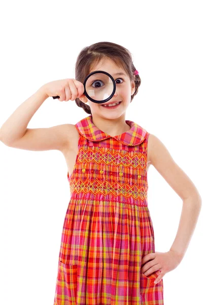 Menina olhando através de uma lupa — Fotografia de Stock