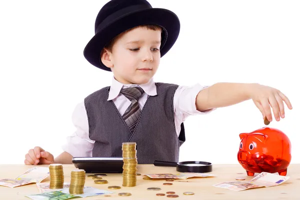 Chlapec u stolu se počítá peníze Stock Obrázky