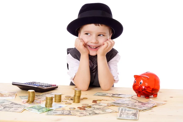 Menino feliz na mesa com dinheiro — Fotografia de Stock