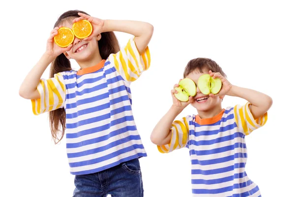 Два веселых ребенка с фруктами на лице — стоковое фото